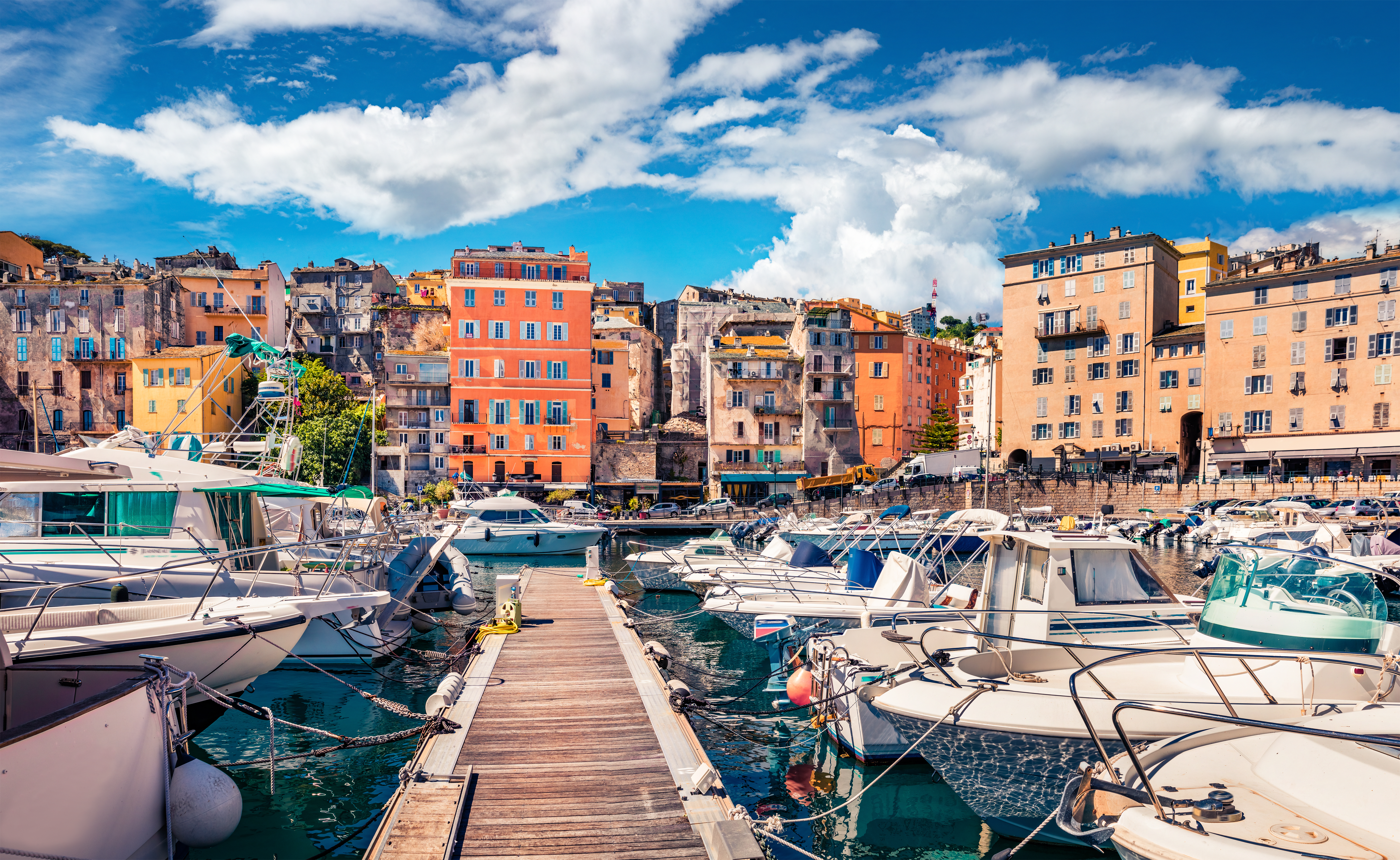 Le port de Bastia Titre de l’image : moby_port-de-bastia Description de l’image : Une vue au premier plan du port de Bastia avec des bateaux amarrés et au second plan des bâtisses colorées typiques de la ville.