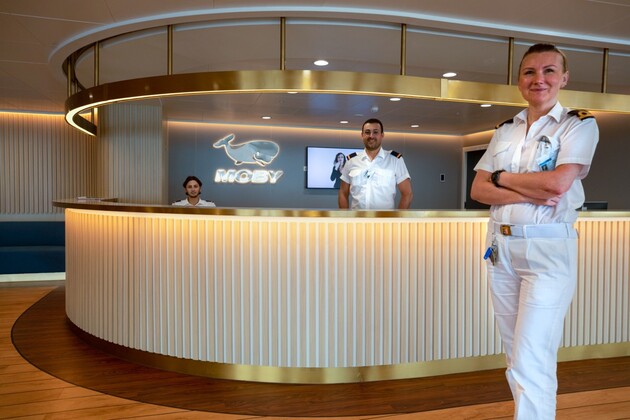 Trois réceptionnistes du ferry Moby Fantasy installés à la réception du bateau
